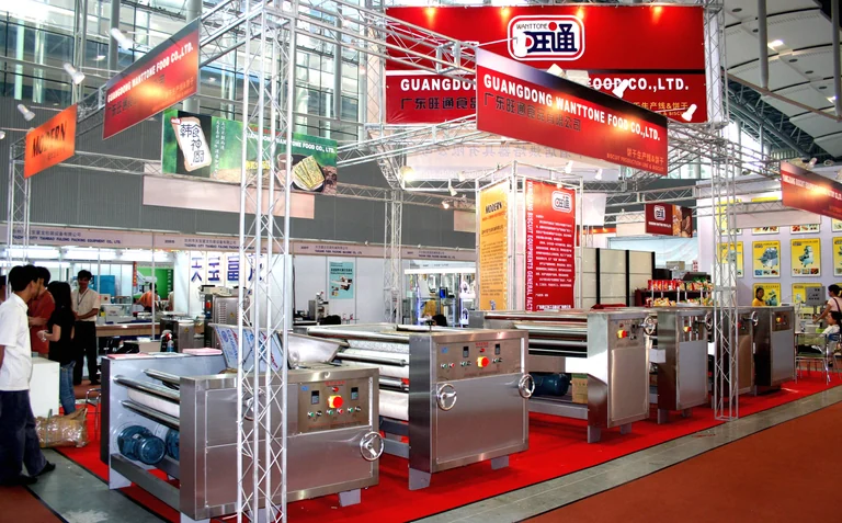 Wanttone exhibition booth with stainless-steel machinery and red overhead signs