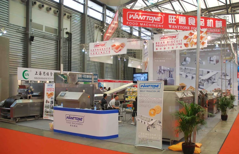 A Wanttone stand with machinery, biscuit displays and visitors