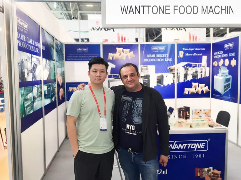 Two people posing together in the Wanttone machinery exhibition booth in Germany
