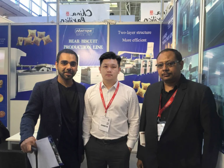 Three people gathered at the Wanttone exhibition booth in Germany