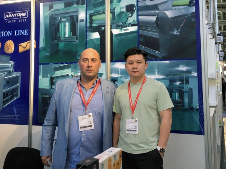 Two people standing at the Wanttone exhibition booth in Germany