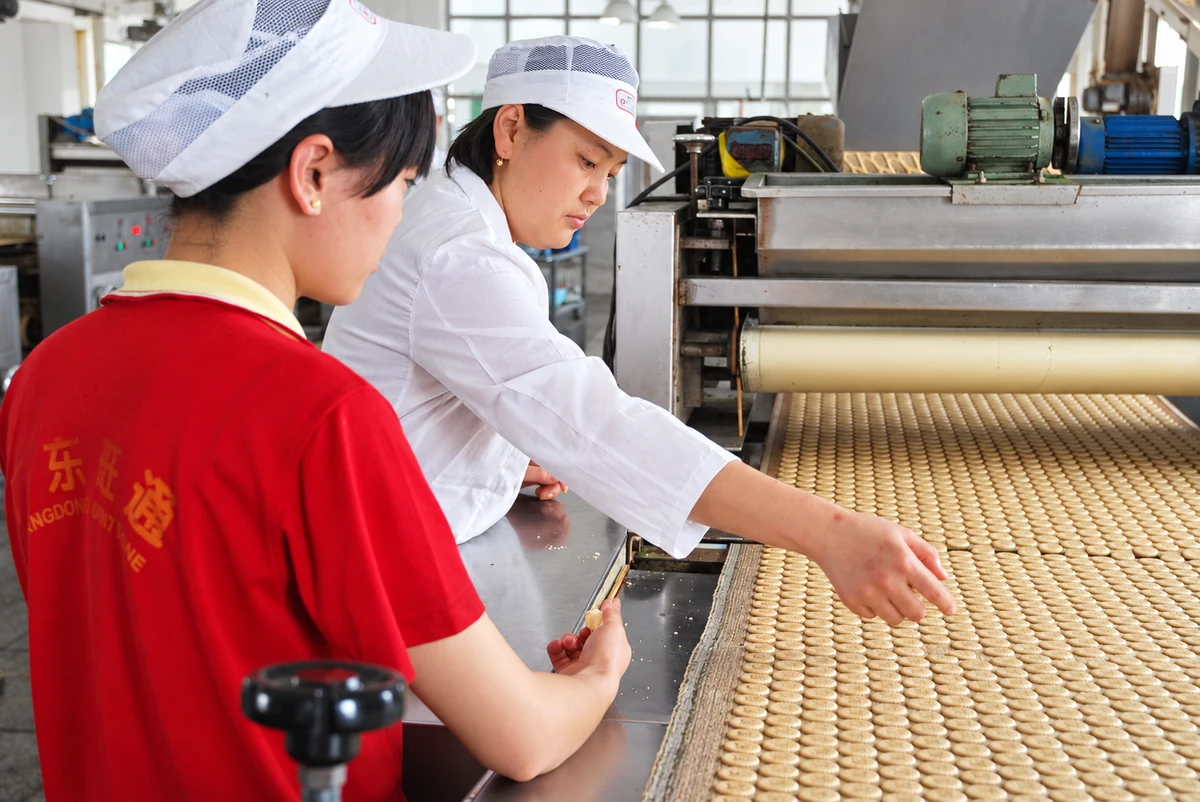 Wanttone production staff checking biscuits on the factory production line